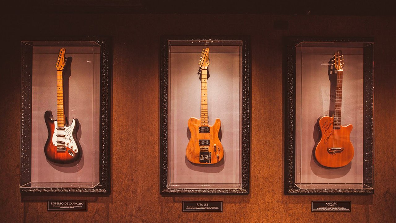 Três guitarras expostas em vitrines com plaquinhas: Roberto de Carvalho, Rita Lee e Xandão